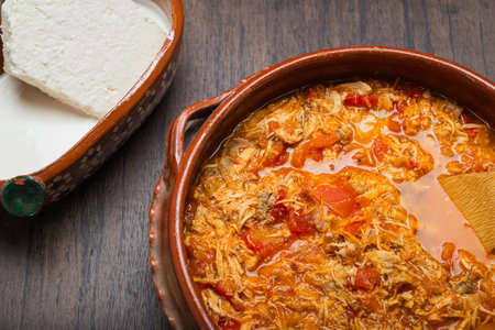 Authentic mexican chicken tinga, typical mexican food prepared in a clay pot on a wooden table.の写真素材