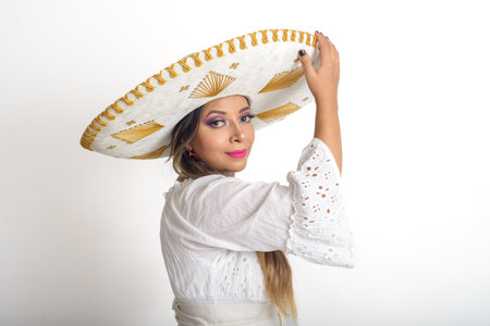 Mexican woman wearing a mariachi hat. Woman with hat, white background.の写真素材
