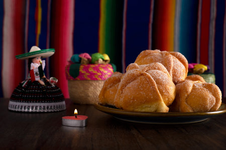 Dead bread and mexican handicrafts with colorful sarape in the background. Typical dessert of the day of the dead.の写真素材