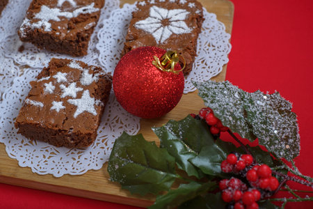 Chocolate brownies with icing sugar decorations together with Christmas decorations. Christmas background and dessert.の写真素材