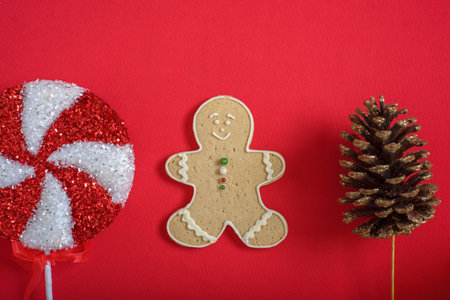 Gingerbread man cookies and christmas ornaments on red background. Christmas background.の写真素材