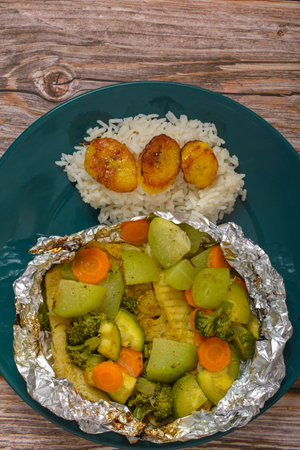 Baked fish with vegetables in aluminum foil. Healthy food.の写真素材
