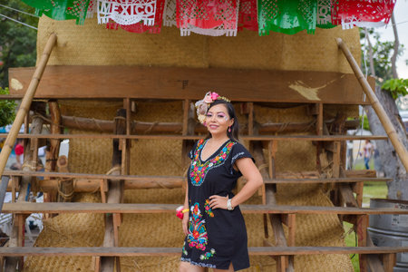 Street portrait of Mexican woman wearing traditional dress with multicolored embroidery. Hispanic woman celebrating independence day.の写真素材