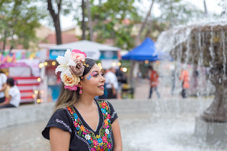 Street portrait of Mexican woman wearing traditional dress with multicolored embroidery. Hispanic woman celebrating independence day.の写真素材