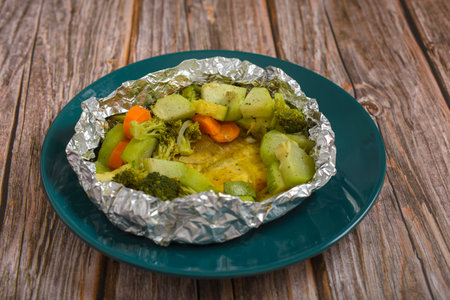Baked fish with vegetables in aluminum foil. Healthy food.の写真素材