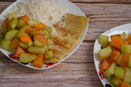Fried fish fillet served with sauteed vegetables and white rice. Healthy meal.の写真素材