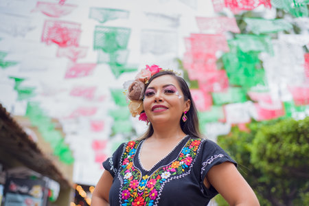 Street portrait of Mexican woman wearing traditional dress with multicolored embroidery. Hispanic woman celebrating the day of the beginning of the Mexican Revolution.の写真素材