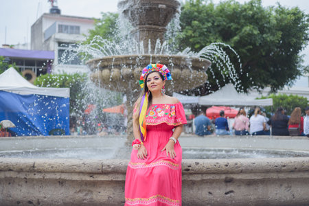 Street portrait of Mexican woman wearing traditional dress with multicolored embroidery. Hispanic woman celebrating the day of the beginning of the Mexican Revolution.の写真素材