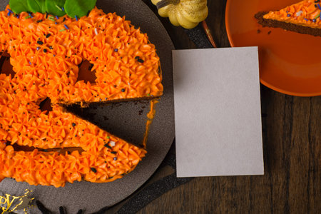 Cake decorated in the shape of a pumpkin with autumn decorations and a blank card. Autumn background.の写真素材