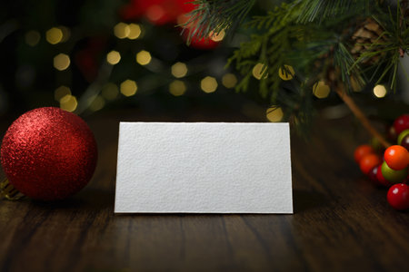 Blank invitation card on wooden table with Christmas ornaments. Blank business card mockup.の写真素材