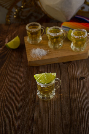 Tequila shots with salt and lime on a bar table. Shots of tequila and typical mexican elements.の写真素材