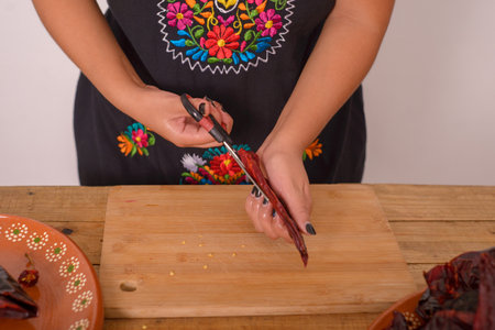 Woman opening ancho chili to remove the seeds. Ancho chili; condiment of Mexican cuisine.の写真素材