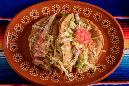 Golden tacos in a clay dish on a colorful serape. Typical Mexican food.の写真素材