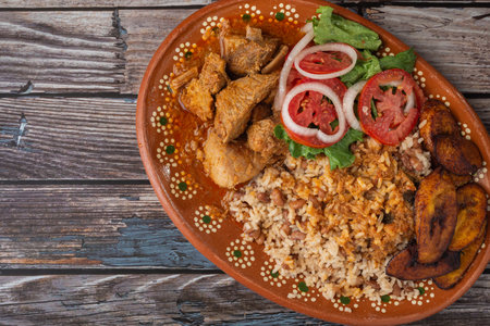 Rice congri with pork fricassee, salad and fried ripe plantain. Typical Cuban food.の写真素材