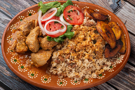 Rice congri with pork fricassee, salad and fried ripe plantain. Typical Cuban food.の写真素材