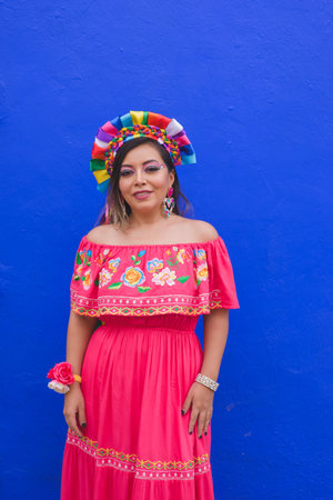 Mexican woman wearing embroidered dress and Lele doll headband. Outdoor portrait.の写真素材