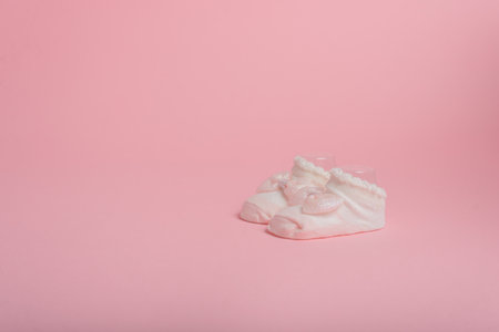 Newborn socks with bow on pink background. Copy space.の写真素材