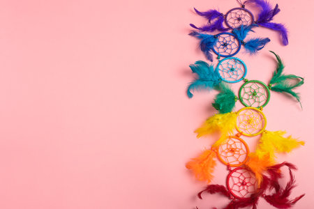 Colorful dreamcatcher on pink background. Dreamcatcher with colorful feathers.の写真素材