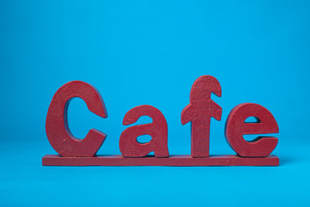 Spanish coffee word carved in wood isolated on blue background.の写真素材