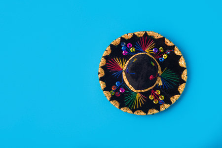 Small Mexican hat isolated on blue background. Mexican souvenir.の写真素材
