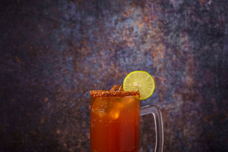 Michelada, typical mexican cocktail on a wooden table. Cocktail based on beer.の写真素材