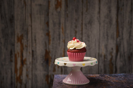Cupcake on small ceramic plate with wooden bottom with copy space. Product photo.の写真素材