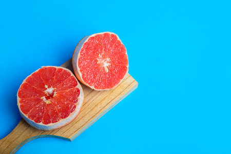Cut pink grapefruit isolated on blue background. Citrus isolated.の写真素材