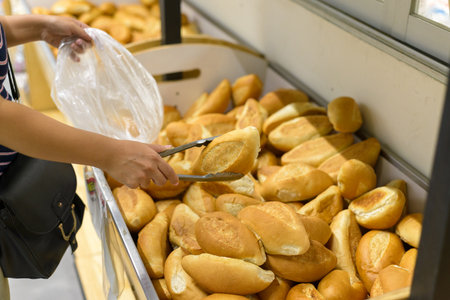 Person selecting breads in a supermarket. Bread stand.