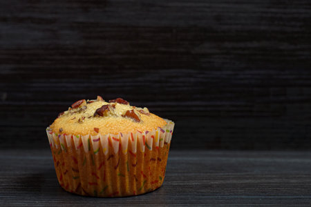 Cupcake with nuts isolated on wooden background. Space for text.の写真素材