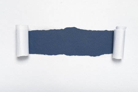 Torn white paper revealing a blue-gray background. Space for text.