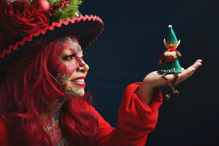 Woman in fantasy Christmas makeup holding a plush elf in her hands.の写真素材