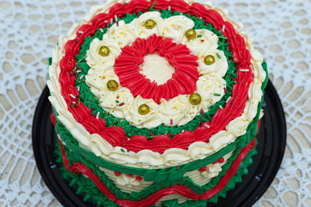 Cake decorated with Christmas colors on a woven tablecloth. Christmas cake.