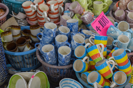 Ceramic pottery vessels stacked on the ground at a flea market in Mexico.
