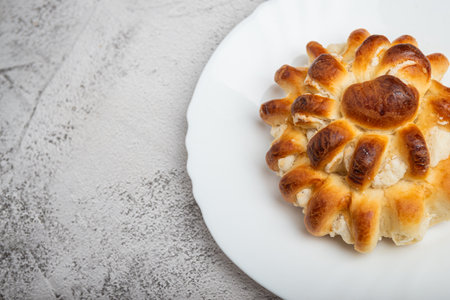 Close-up of a freshly baked stuffed bun on a white plate.の写真素材