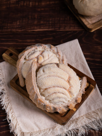 Concha breads, dusted with sugar, rest on a rustic wooden board