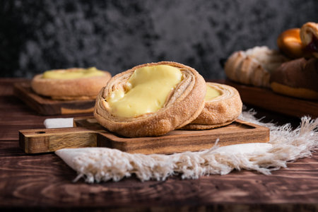 Close-up of two delicious cream-filled pastries, sprinkled with sugar, on a wooden board.の写真素材