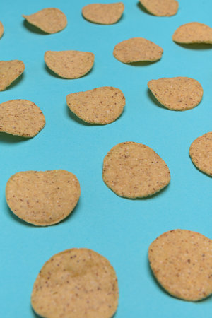 Numerous round nachos carefully arranged on a light blue-green background.の写真素材