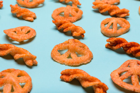 Various shapes of crispy seasoned flour duritos arranged on a pastel blue background.