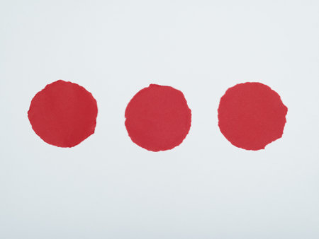 Three Red Circular Paper Cutouts on White Background.の写真素材