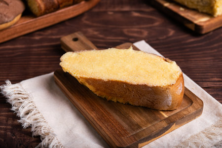 A delicious slice of buttered sweet bread, browned and generously coated with sugar, rests on a...