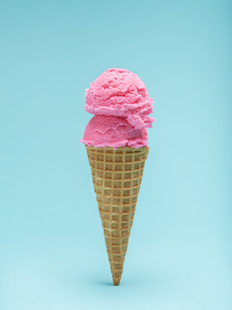 Two scoops of vibrant pink ice cream atop a crispy waffle cone, set against a bright blue backdrop.