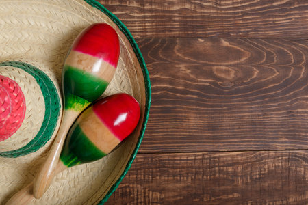 Maracas and Mexican hat on wooden table. Mexican background.