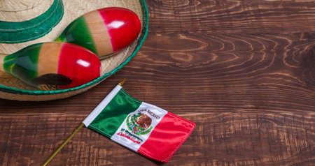 Maracas, Mexican flag and Mexican hat on wooden table. Mexican background.