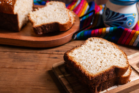 Salvadoran yolk bread, accompanied by a cup of hot chocolate.