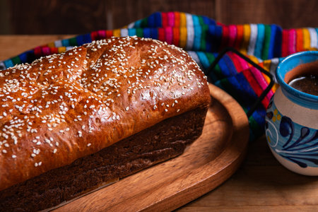 Salvadoran yolk bread, accompanied by a cup of hot chocolate.
