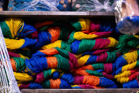Piles of colorful, hand-woven hammocks, rolled up and arranged in a metal container.
