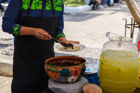 Mexican Street Food Vendor Preparing Mole on Tortillaの写真素材