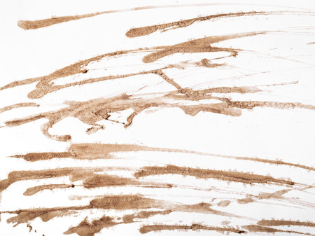 Abstract coffee streaks pattern against a stark white backdrop.の写真素材