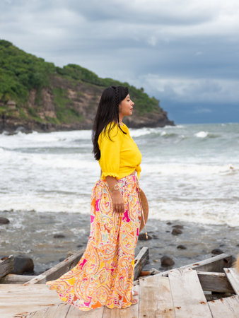 Side View of a Woman in Bohemian Style Skirt on Seashoreの写真素材
