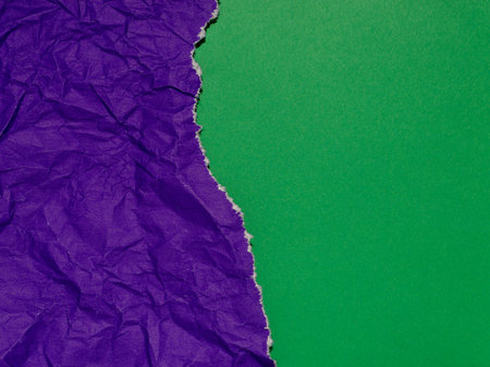Torn purple paper on a green background.の写真素材